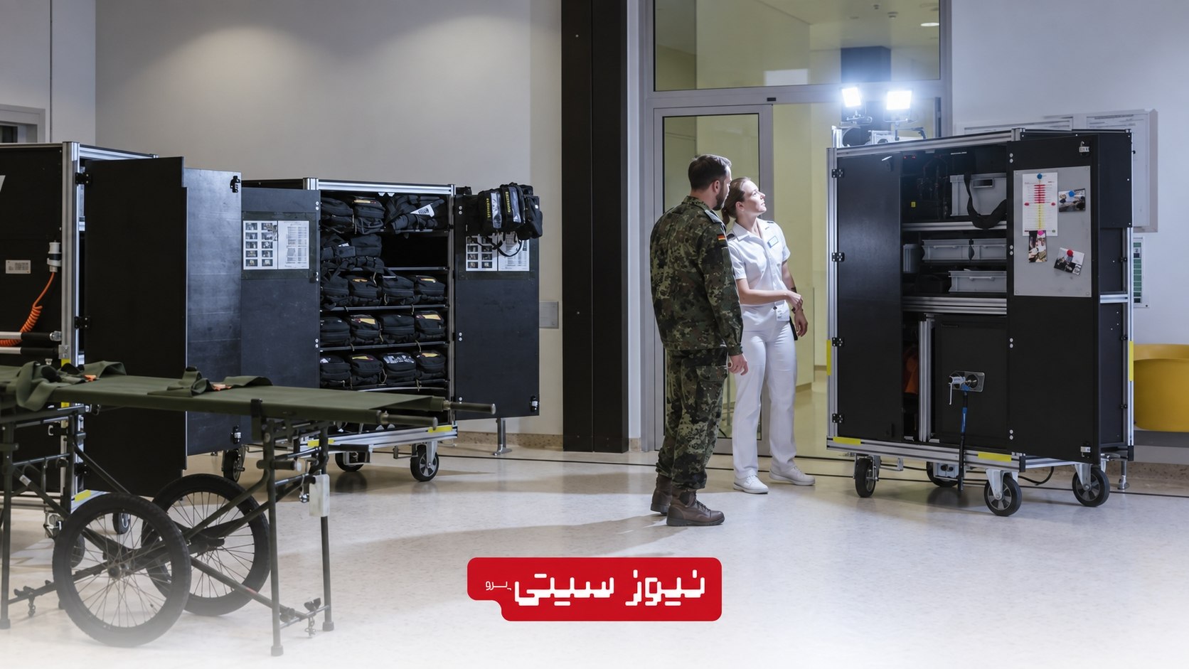 بیمارستانهای آلمان برای جنگ احتمالی آماده میشوند؛ سناریوی روزانه 1,000 مجروح 3 Alt Text: سرباز ارتش آلمان و یکی از کارکنان کادر درمان در کنار برانکارد و تجهیزات پزشکی اضطراری در بیمارستان نظامی اولم